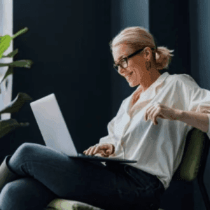Woman working on laptop near window